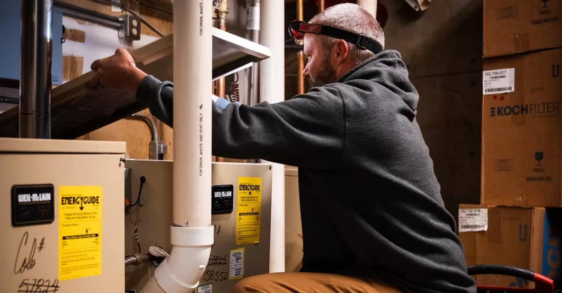 furnace technician working on heating system