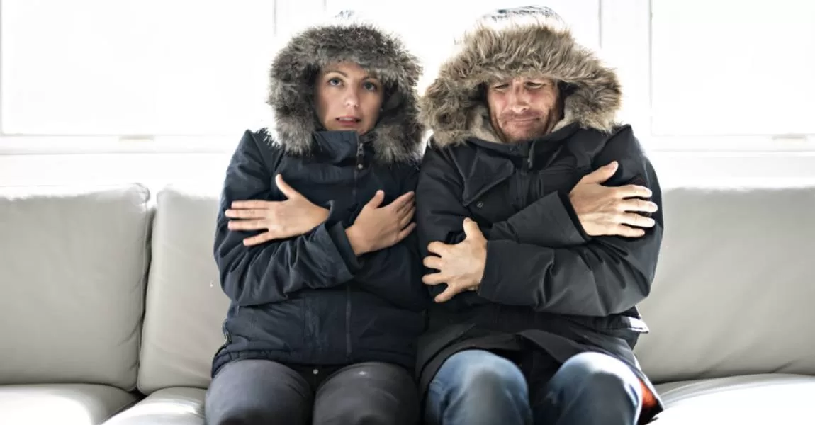 man and woman freezing on couch broken furnace